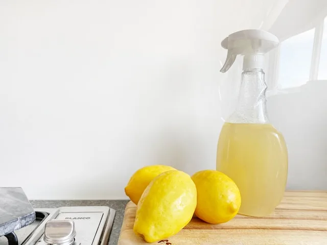 Eco-friendly cleaning spray and lemons on an office kitchen worktop