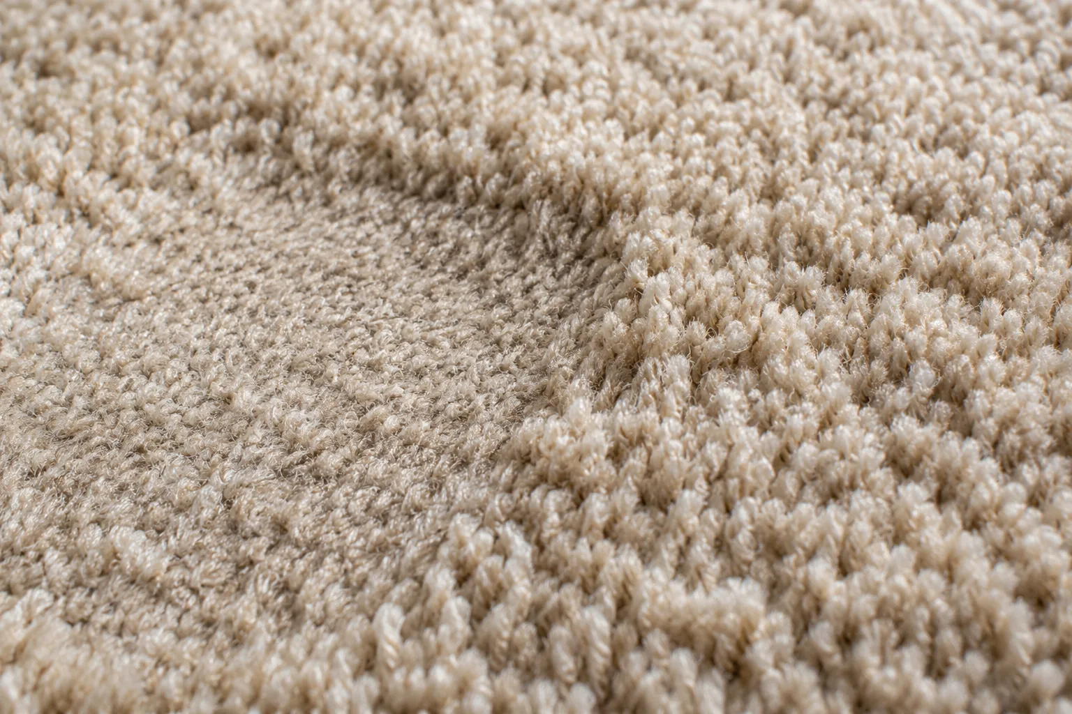 Close view of flattened carpet pile beside raised fibres